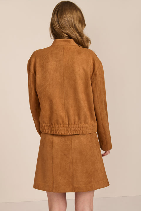 women's camel faux suede bomber jacket with a tonal snap front and flap pockets, styled with the coordinating mini skirt.