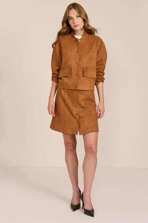 women's camel faux suede bomber jacket with a tonal snap front and flap pockets, styled with the coordinating mini skirt.