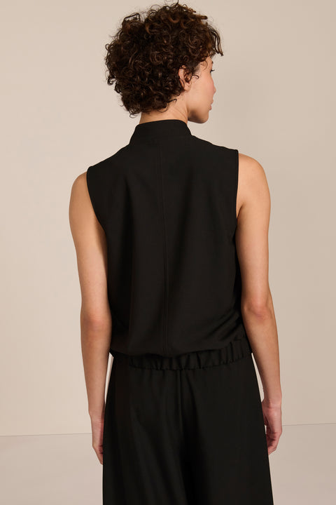 women's black sleeveless utility bomber vest featuring a stand collar, snap-front closure, flap pockets and elasticized hem.
