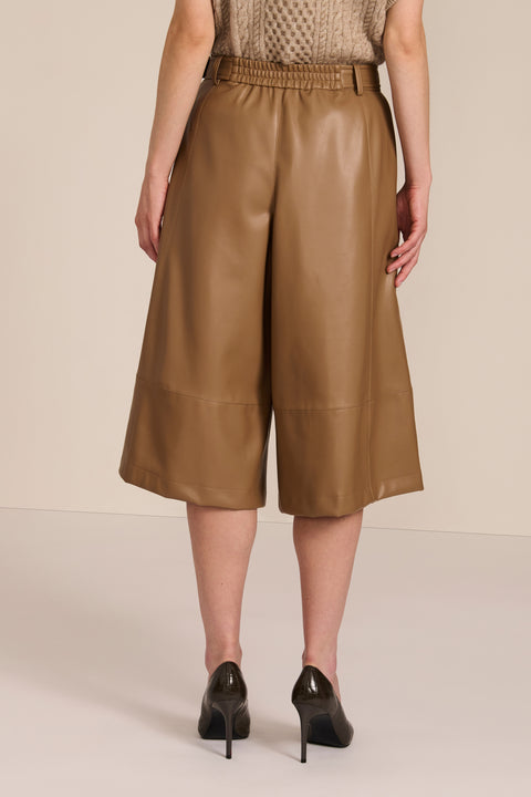 women's camel faux leather culottes featuring a high waist, self belt, wide cropped leg and paneled seam detailing.