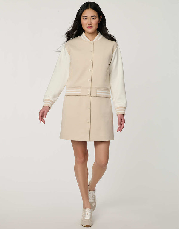 Woman wearing neutral Modern Varsity Jacket with contrast sleeves, ribbed trim, snap-front closure and welt pockets.