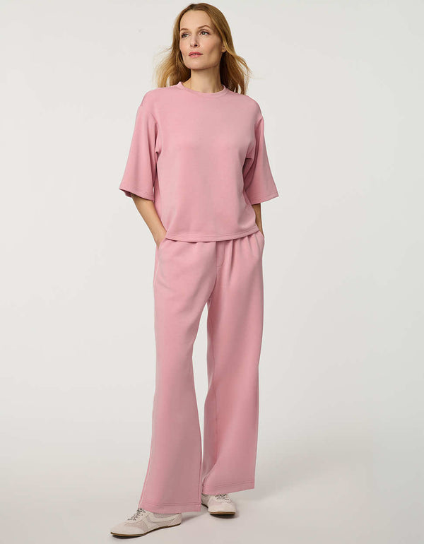 Woman wearing Relaxed Scuba Drop-Shoulder Tee with elbow-length sleeves and modern oversized silhouette.