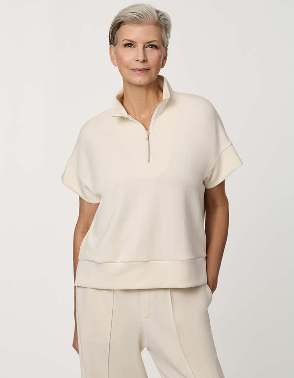 Woman wearing Half-Zip Scuba Pullover Top with stand collar and short sleeves.