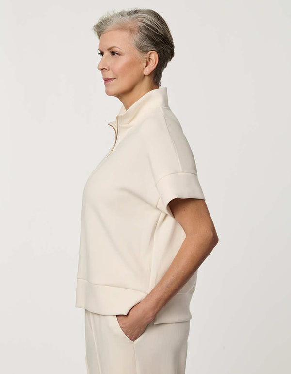 Woman wearing Half-Zip Scuba Pullover Top with stand collar and short sleeves.