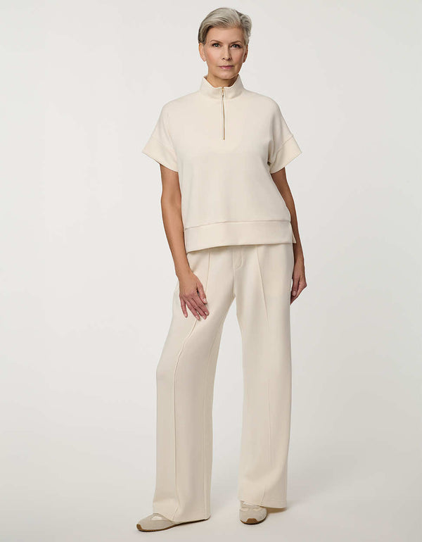 Woman wearing Half-Zip Scuba Pullover Top with stand collar and short sleeves.