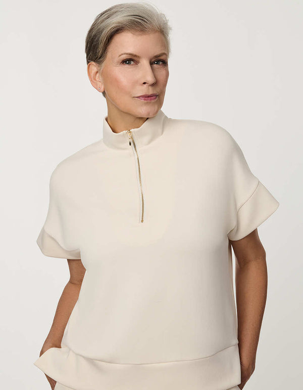 Woman wearing Half-Zip Scuba Pullover Top with stand collar and short sleeves.