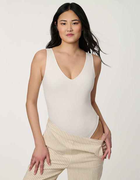 Women’s fitted jersey V-neck bodysuit in Bright White with sleeveless silhouette and smooth finish.