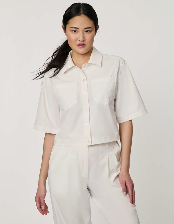 Women’s bright white cropped poplin shirt with short sleeves, button front, patch pockets, and relaxed fit.