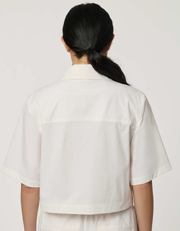 Women’s bright white cropped poplin shirt with short sleeves, button front, patch pockets, and relaxed fit.