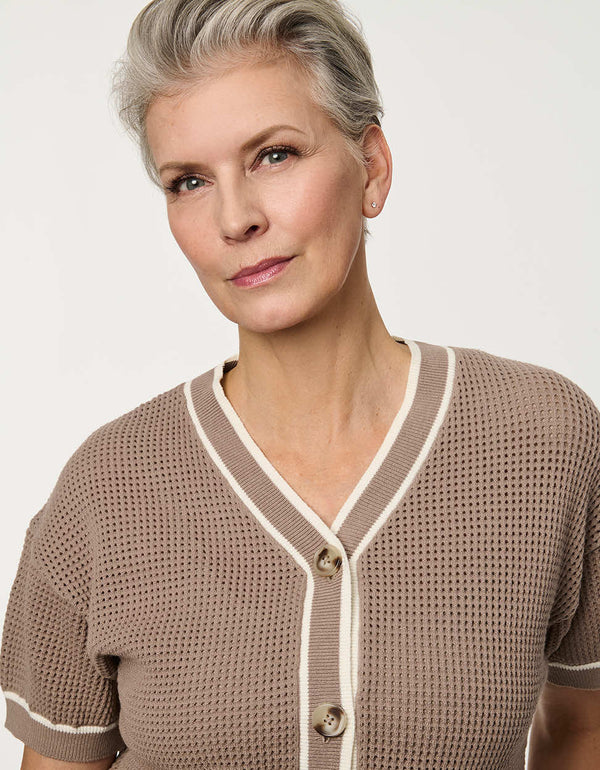 Woman wearing short-sleeve Basketweave Knit Cardigan with textured knit pattern and contrast trim detailing.