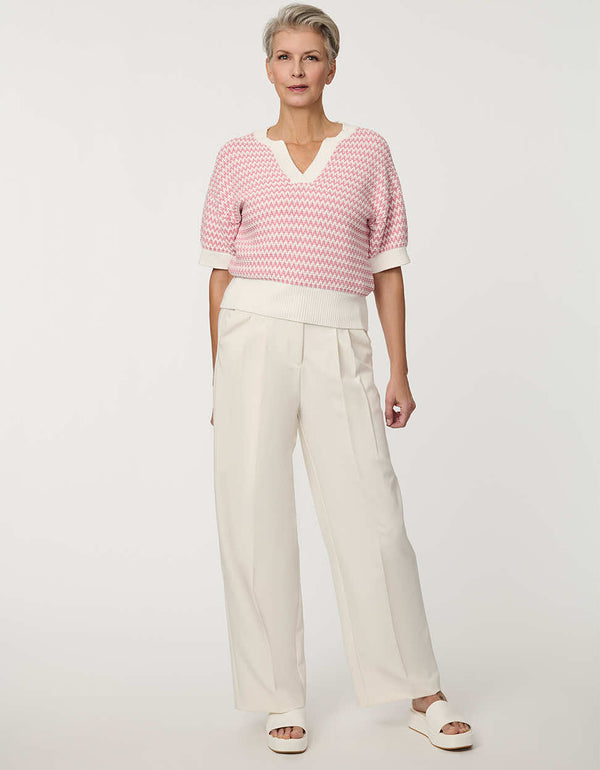 Woman wearing short-sleeve Jacquard Knit Popover Sweater with textured pattern and V-neckline.