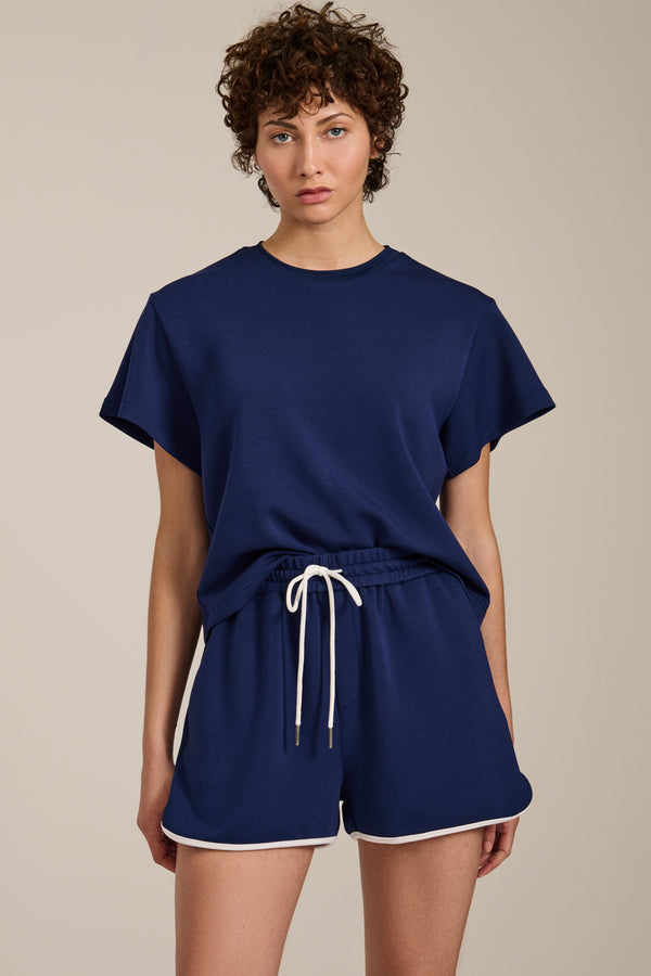 Woman wearing cropped short sleeve tee in featherweight scuba with contrast trim detail and relaxed fit.