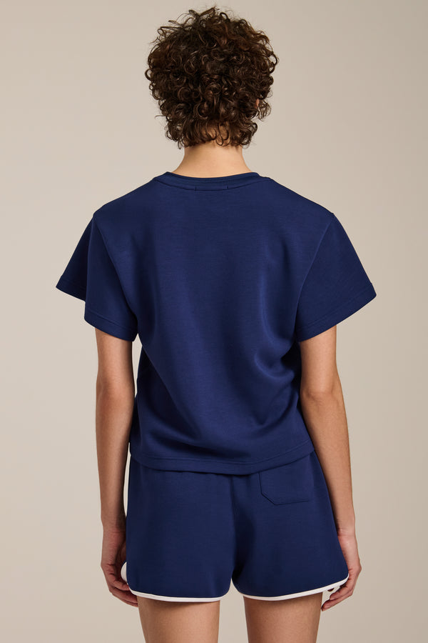 Woman wearing cropped short sleeve tee in featherweight scuba with contrast trim detail and relaxed fit.