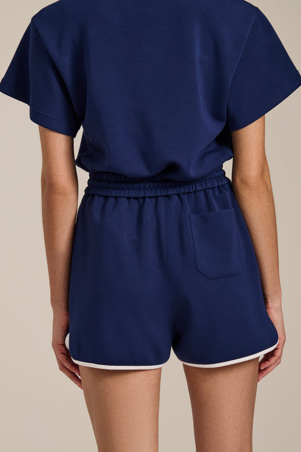 Woman wearing dolphin featherweight scuba shorts with elastic drawstring waist and contrast trim detail.