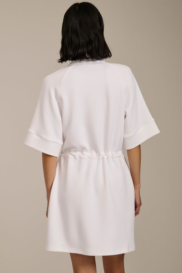 Woman wearing featherweight scuba quarter zip dress with drawcord waist, short sleeves, and side pockets.