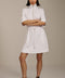 Woman wearing featherweight scuba quarter zip dress with drawcord waist, short sleeves, and side pockets.