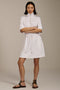 Woman wearing featherweight scuba quarter zip dress with drawcord waist, short sleeves, and side pockets.