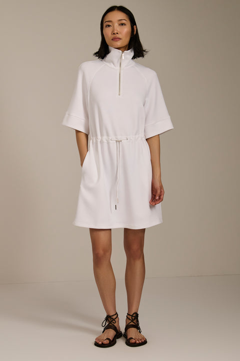 Woman wearing featherweight scuba quarter zip dress with drawcord waist, short sleeves, and side pockets.