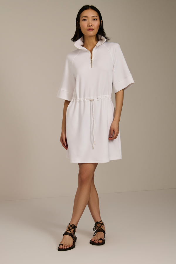 Woman wearing featherweight scuba quarter zip dress with drawcord waist, short sleeves, and side pockets.
