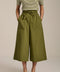 Woman wearing tech poplin wide leg culotte pants with elastic waist and patch pockets.