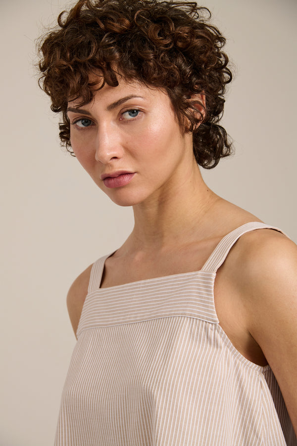 Woman wearing striped sleeveless tank top with square neckline and relaxed fit.