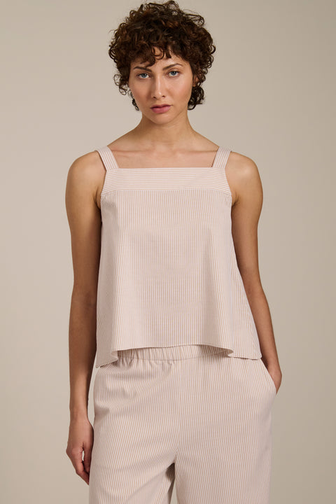 Woman wearing striped sleeveless tank top with square neckline and relaxed fit.