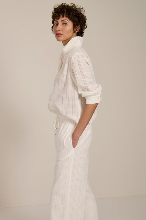Woman wearing jacquard plaid button-up shirt with balloon sleeves and relaxed fit.