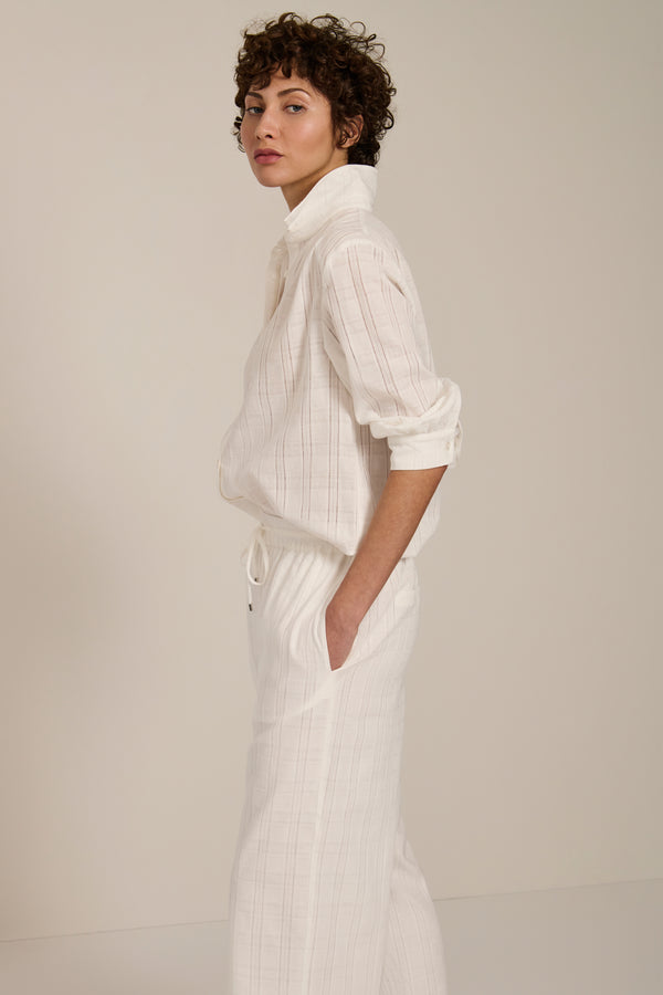 Woman wearing jacquard plaid button-up shirt with balloon sleeves and relaxed fit.
