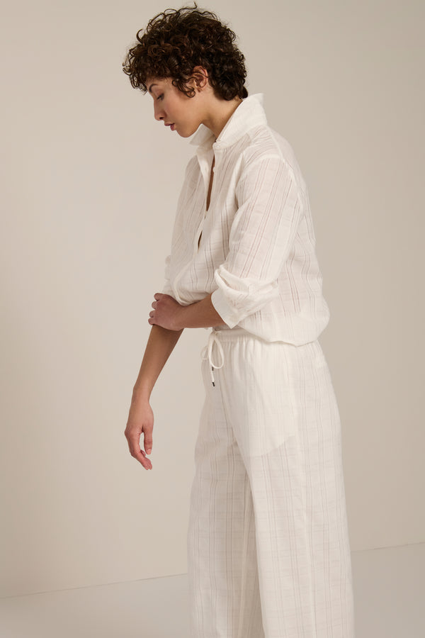 Woman wearing jacquard plaid button-up shirt with balloon sleeves and relaxed fit.