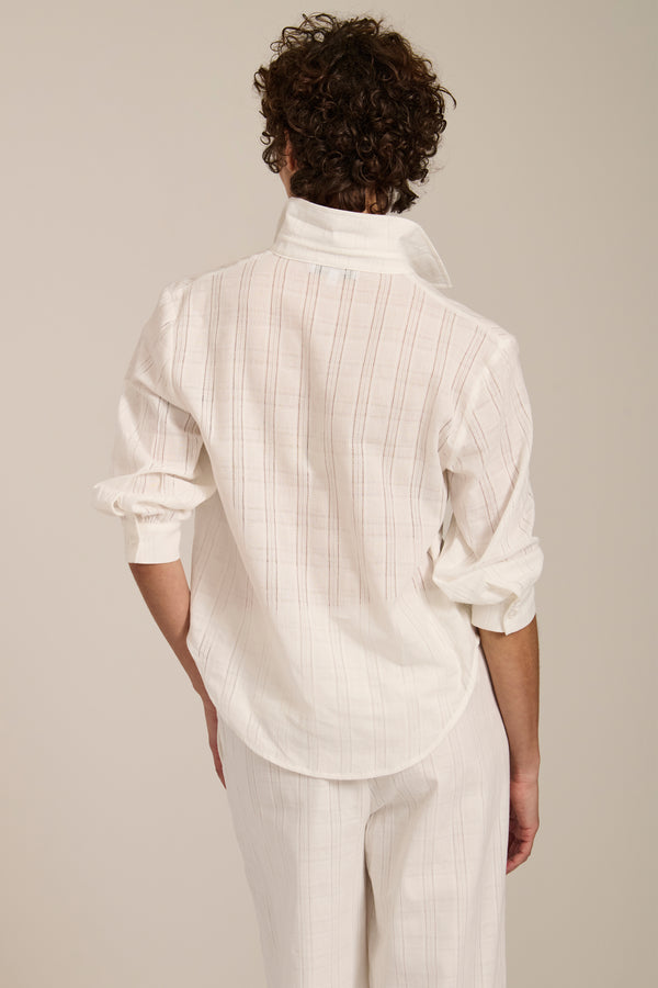 Woman wearing jacquard plaid button-up shirt with balloon sleeves and relaxed fit.