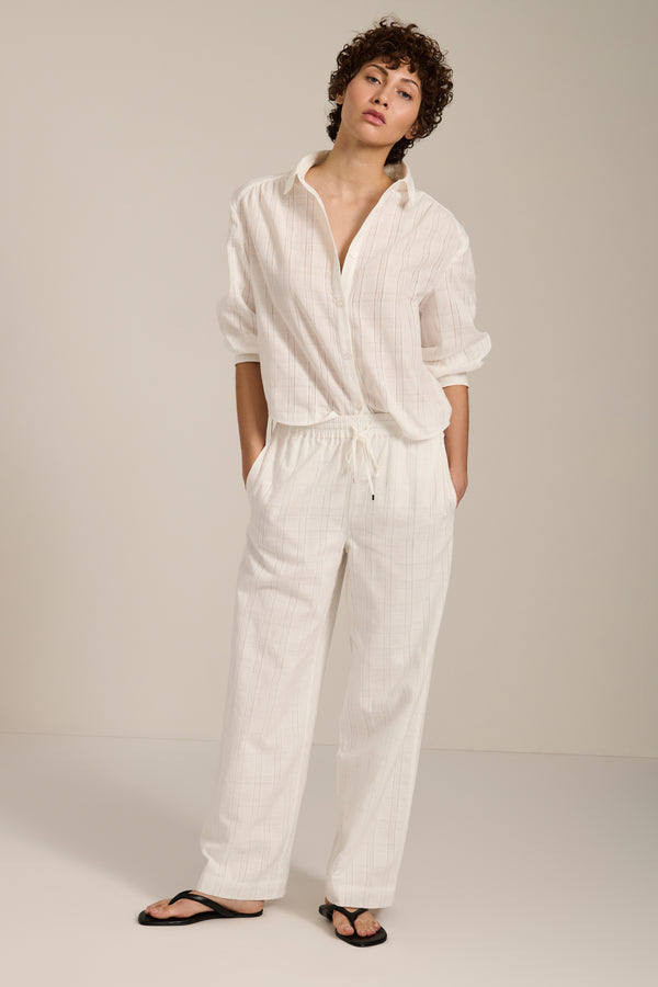 Woman wearing jacquard plaid button-up shirt with balloon sleeves and relaxed fit.