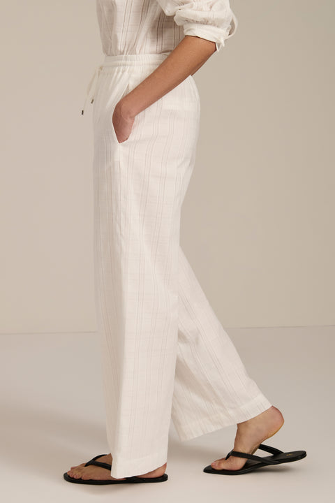 Woman wearing jacquard plaid relaxed pants with elastic drawstring waist and straight leg silhouette.