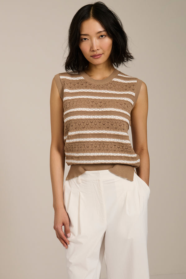 Woman wearing sleeveless striped pointelle knit top with textured openwork detailing.