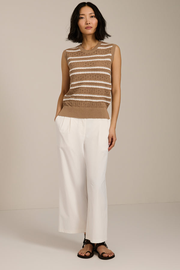 Woman wearing sleeveless striped pointelle knit top with textured openwork detailing.