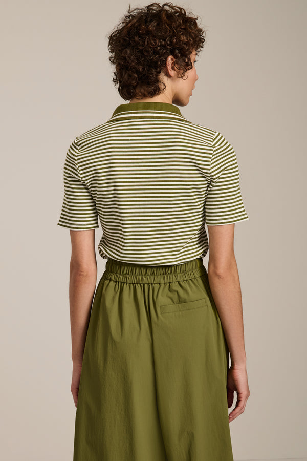 Woman wearing striped short sleeve polo sweater with collared neckline and fitted silhouette.