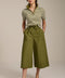 Woman wearing striped short sleeve polo sweater with collared neckline and fitted silhouette.