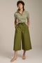 Woman wearing striped short sleeve polo sweater with collared neckline and fitted silhouette.