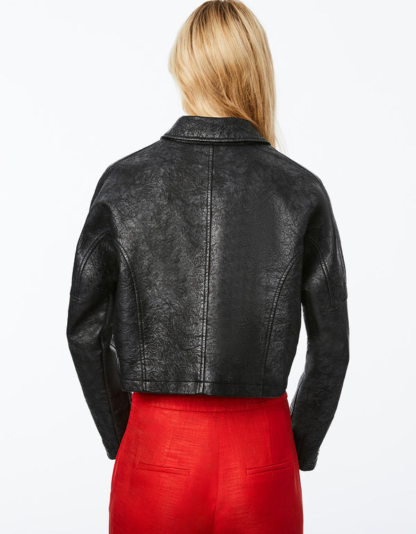 back of a cropped leather jacket for women that features a crackled faux leather texture and snap flap pockets