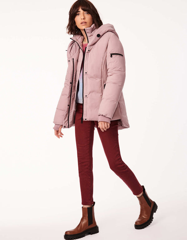 woman in light pink hip length puffer jacket and heavy winter coat in one to help her stay warm in all season long