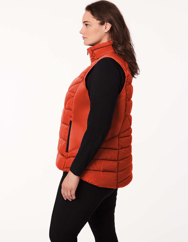 plus sized woman wearing a essential layering piece soft and lightweight puffer vest in orange