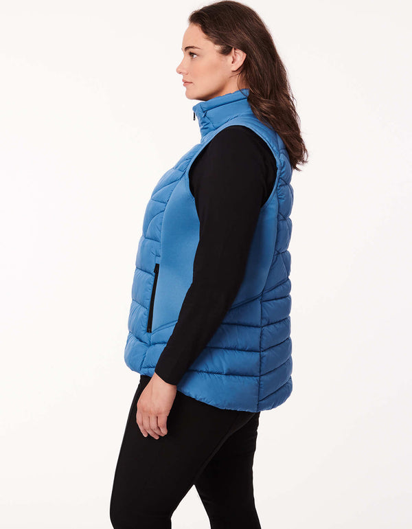 plus sized woman wearing a essential layering piece soft and lightweight puffer vest in blue