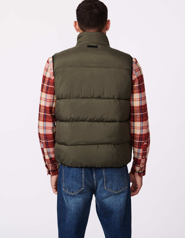 shot from the back of a winter green zip off vests for outdoorsy men with vertical zippers on the chest