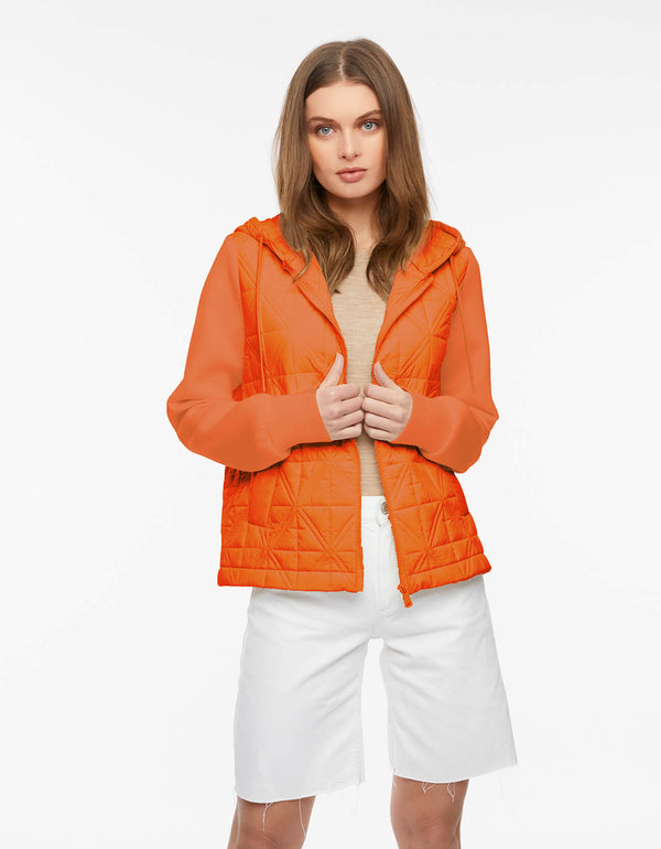 orange oversized hip length puffer jacket for women featuring quilted design and neoprene sleeves and drawstring hood